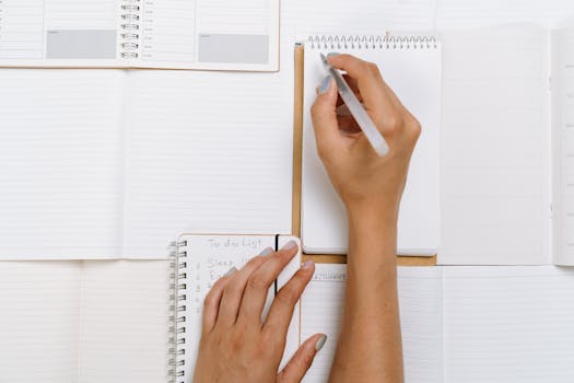 Close-up of hands writing on notepads with a to-do list. Perfect for productivity or organization themes.